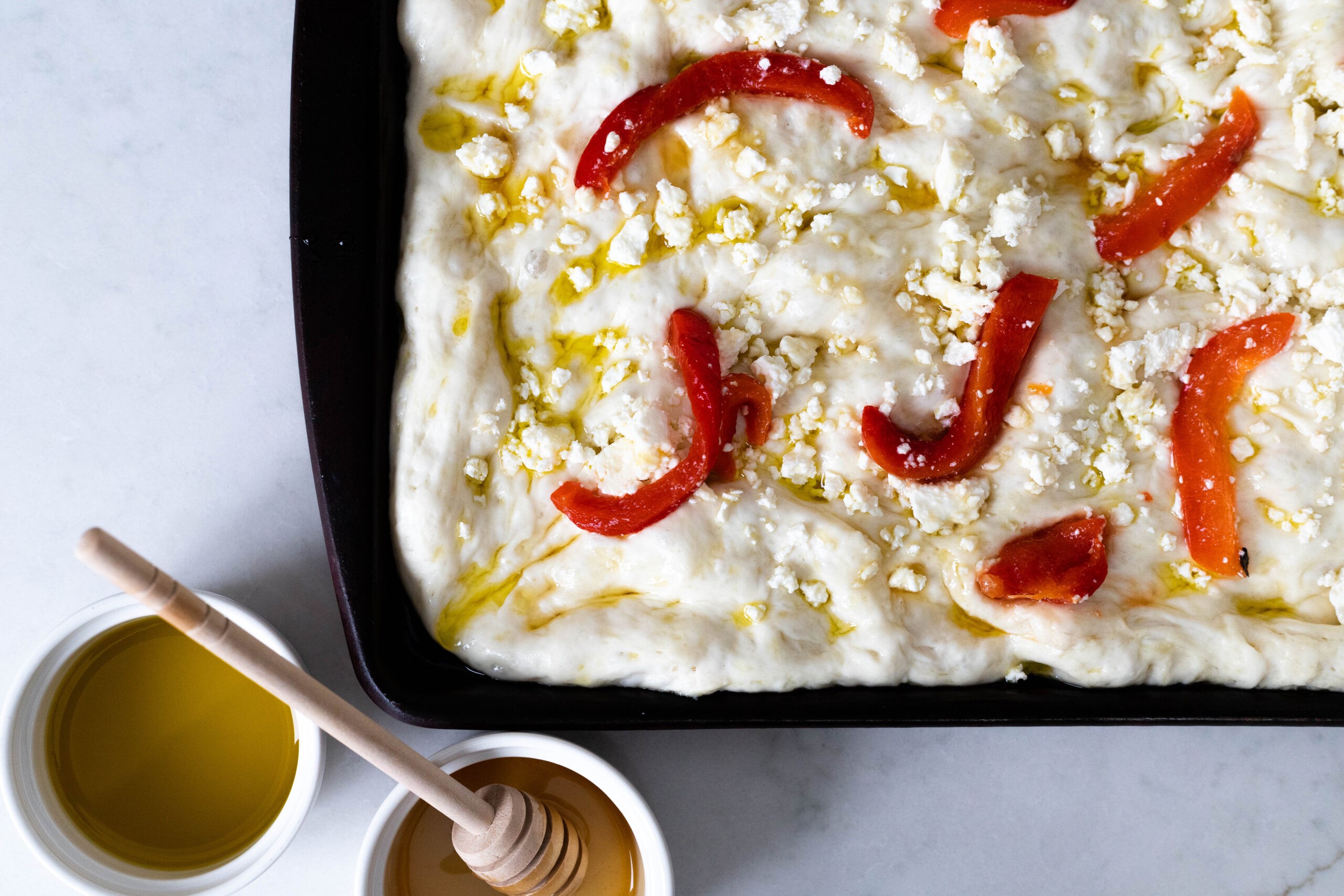 Focaccia dough with roasted red peppers, feta cheese, honey and olive oil